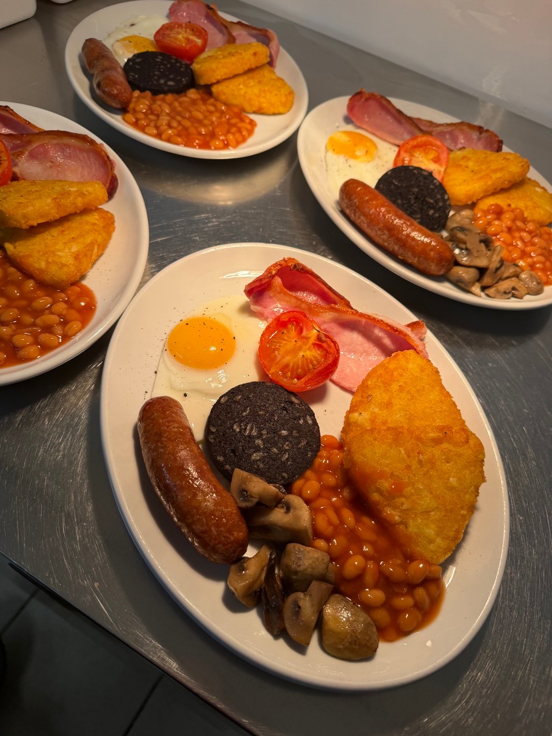 A full English breakfast with bacon, sausage, black pudding, egg, hash brown, beans, mushrooms and tomato