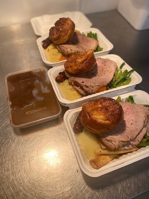 Sunday roast takeaway trays with meat, Yorkshire pudding, vegetables and gravy