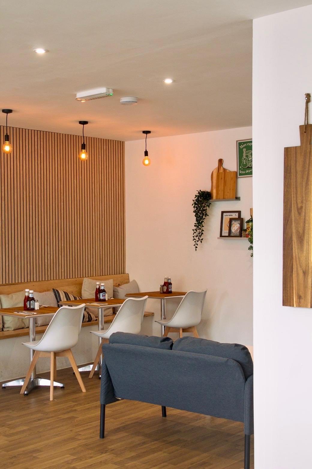 Booth seating with wood panelling, cushions and pendant lighting