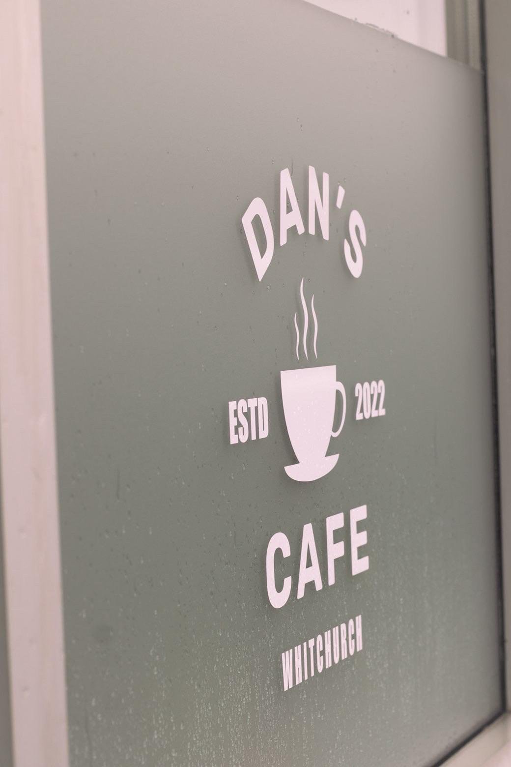 Dan's Cafe logo on the sage green door